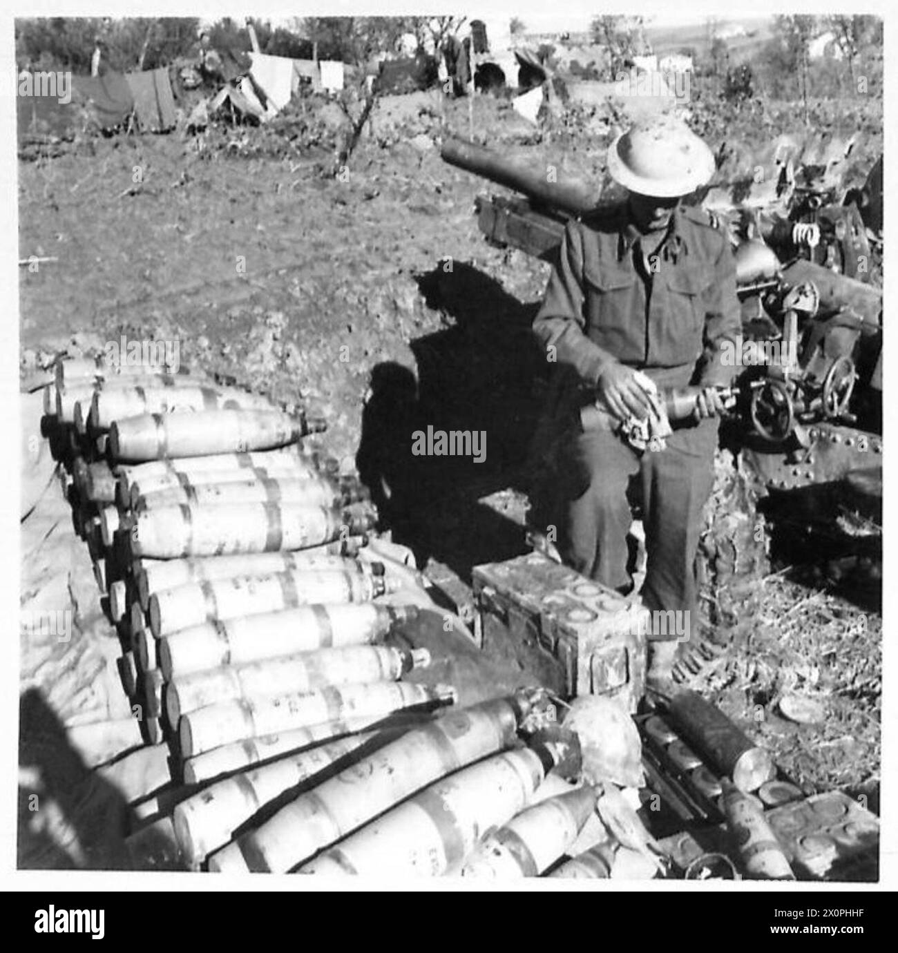 Gunner I. Gausel of the New Zealand troops cleans 25-pounder shells ...