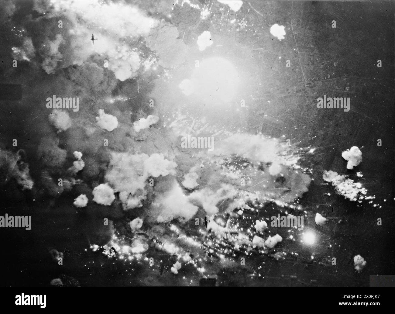Vertical aerial photograph of Pforzheim, Germany, during the first area-bombing raid. High explosive and incendiary bombs detonate as three Avro Lancaster bombers overfly the target, illustrating RAF Bomber Command operations. Photographic negative, Royal Air Force. Stock Photo