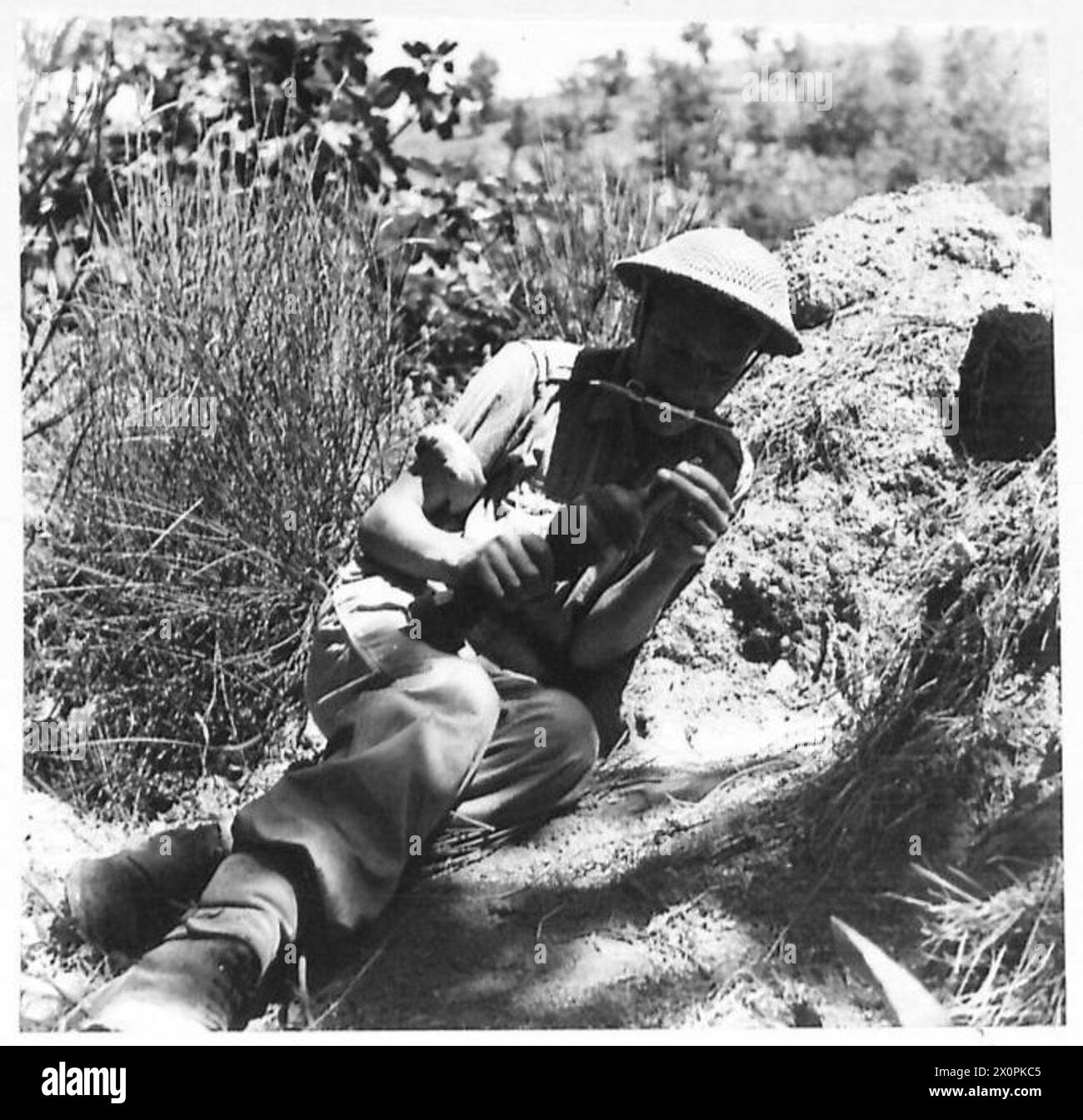 EIGHTH ARMY : BATTLE FOR AREZZO - Rfn. W. Varley of Ipswich, with clasp knife in his teeth, primes a bomb for the P.I.A.T. Photographic negative , British Army Stock Photo