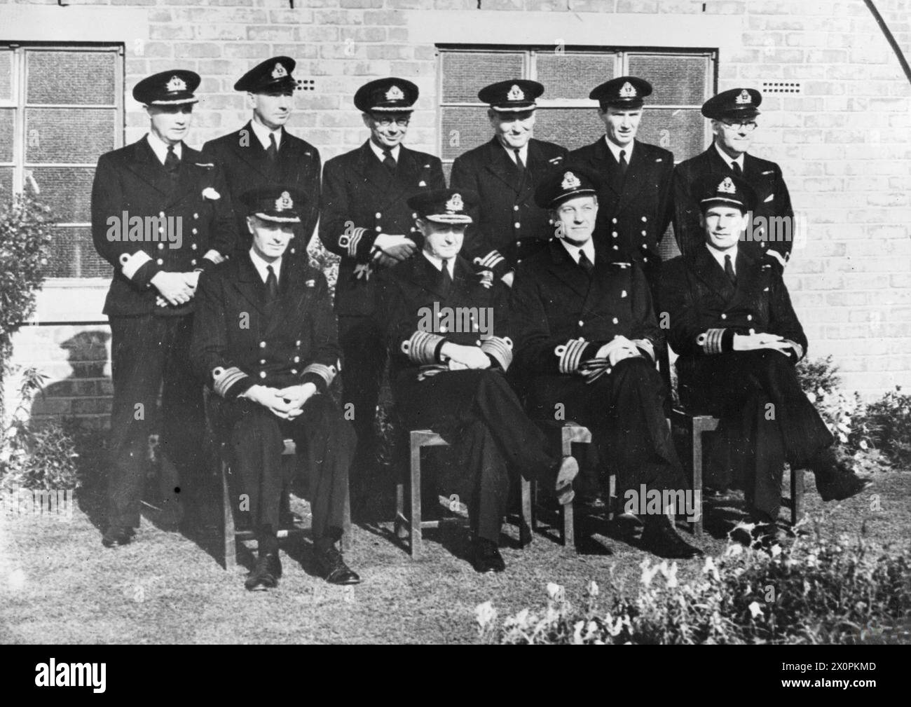 THE FIRST SEA LORD AT A FLEET AIR STATION. 18 OCTOBER 1944, HMS NIGHTJAR, ROYAL NAVAL AIR STATION INSKIP, PRESTON, LANCS. THE VISIT OF THE FIRST SEA LORD, ADMIRAL OF THE FLEET SIR ANDREW CUNNINGHAM. - Back row: Pay Commander H T Isaac, OBE, RN; Lieut Cdr J A Ivers, RN; Commander (A) Nicholson, RNVR; Commander F G Emley, RN; Lieut Cdr E B Morgan, RANVR; Pay Lieut J E Bryon, RNVR. Seated: Captain W T Couchman, OBE, DSO, RN; 1st Sea Lord; Captain J B Heath, RN; Captain G Thistleton-Smith, GM, RN Stock Photo