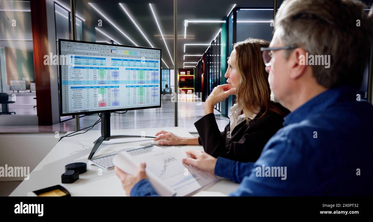 Analyst Employee Working On Spreadsheet Using Desktop Computer Stock Photo