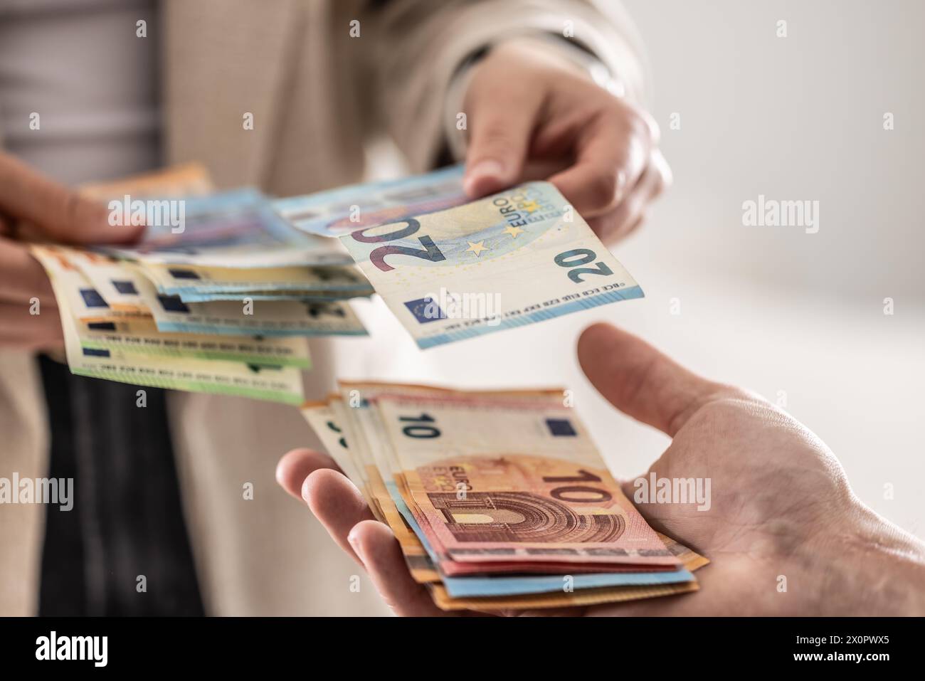 Businesswoman's hands exchanging euro banknotes, closeup shot. Stock Photo