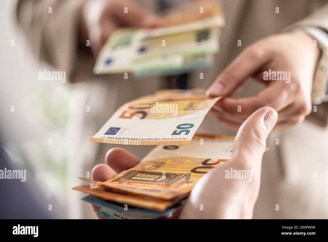 Businesswoman's hands exchanging euro banknotes, closeup shot. Stock Photo