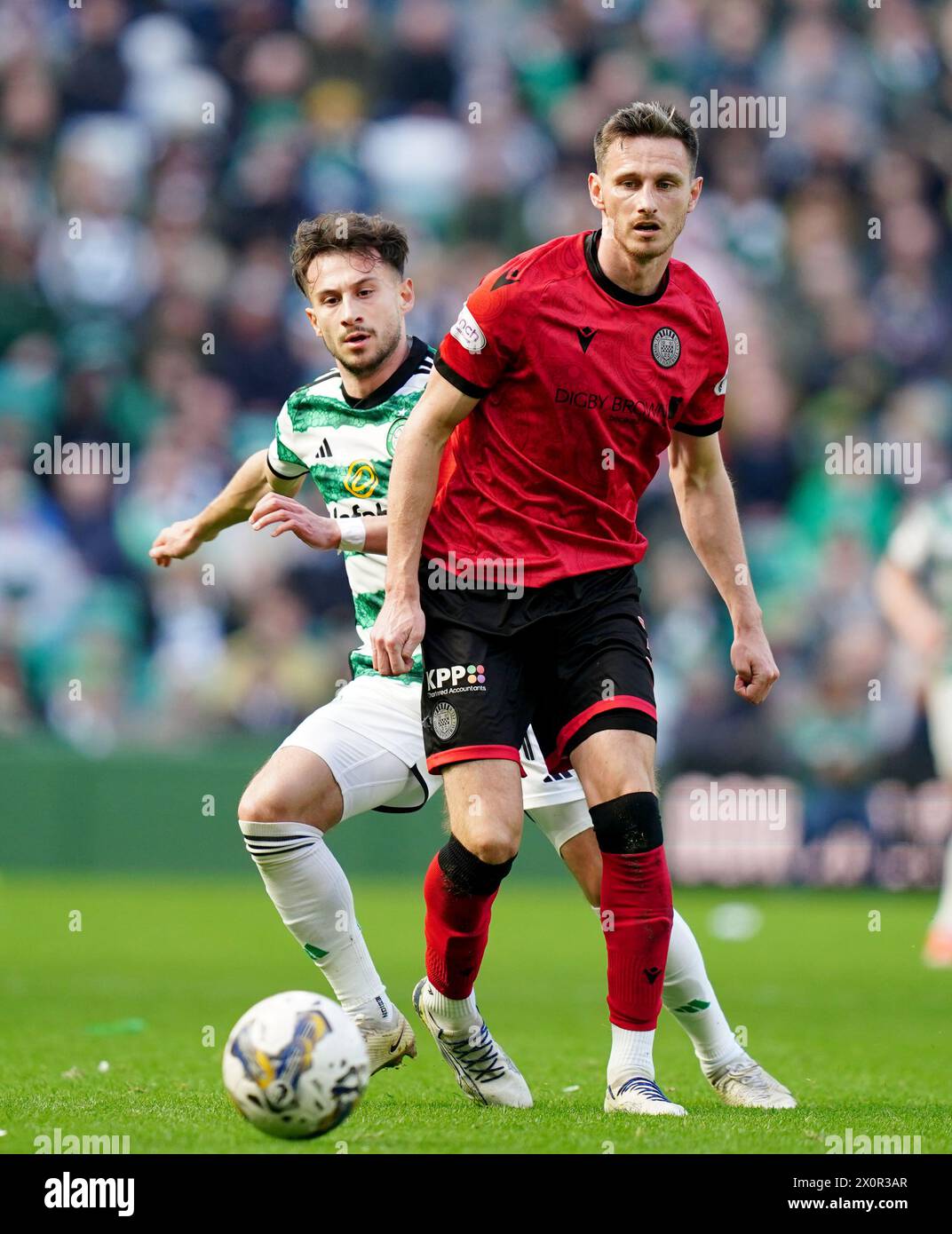 Celtic's Nicolas Kuhn (left) and St Mirren's Scott Tanser battle for the ball during the cinch Premiership match at Celtic Park, Glasgow. Picture date: Saturday April 13, 2024. Stock Photo