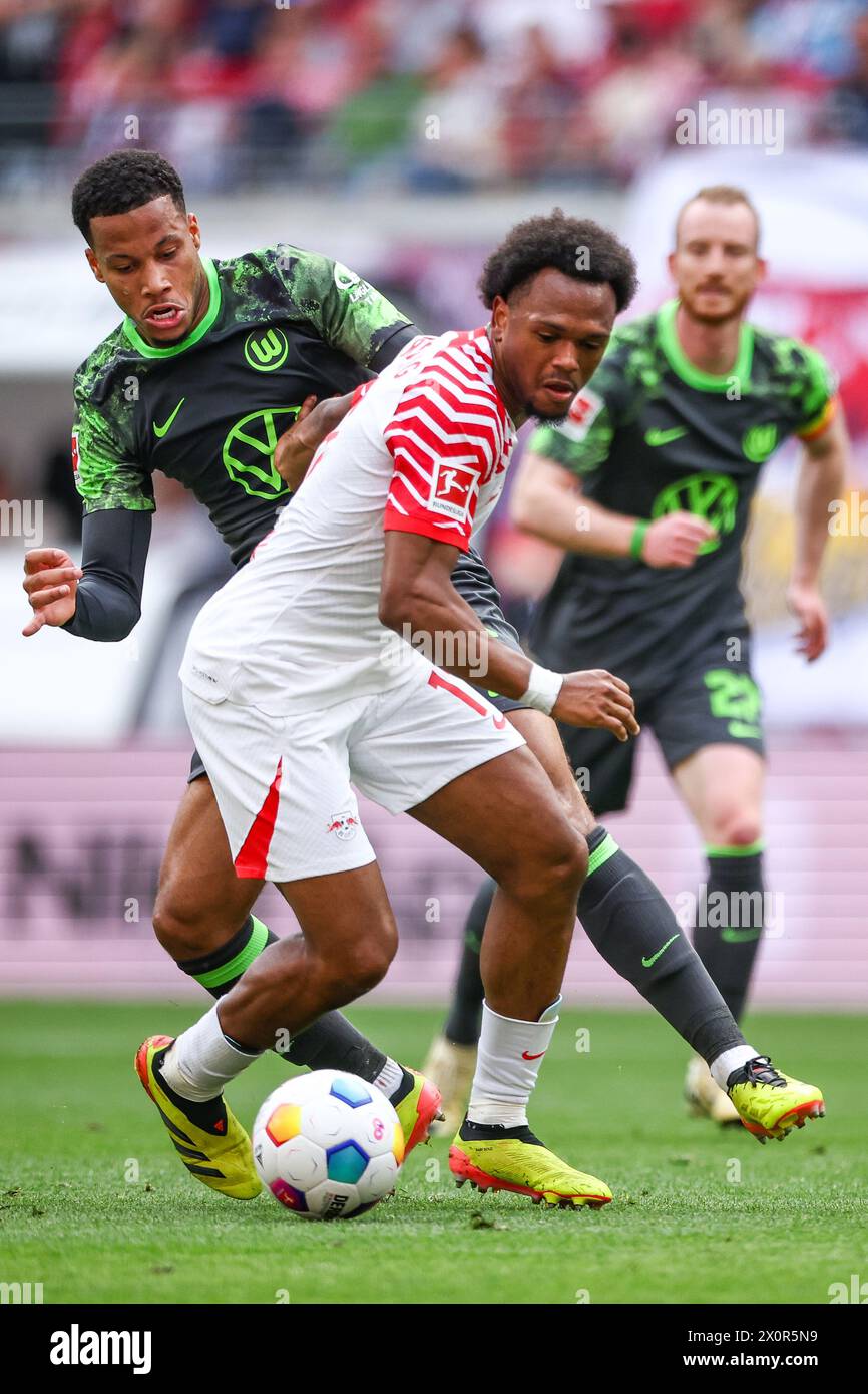 Leipzig, Germany. 13th Apr, 2024. Soccer: Bundesliga, RB Leipzig - VfL Wolfsburg, matchday 29 at the Red Bull Arena. Leipzig player Lois Openda (r) and Wolfsburg's Aster Vranckx in a duel. Credit: Jan Woitas/dpa - IMPORTANT NOTE: In accordance with the regulations of the DFL German Football League and the DFB German Football Association, it is prohibited to utilize or have utilized photographs taken in the stadium and/or of the match in the form of sequential images and/or video-like photo series./dpa/Alamy Live News Stock Photo