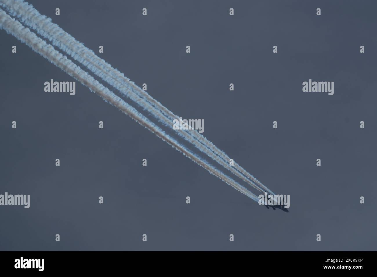 airplane in the cloudy sky with contrail Stock Photo - Alamy