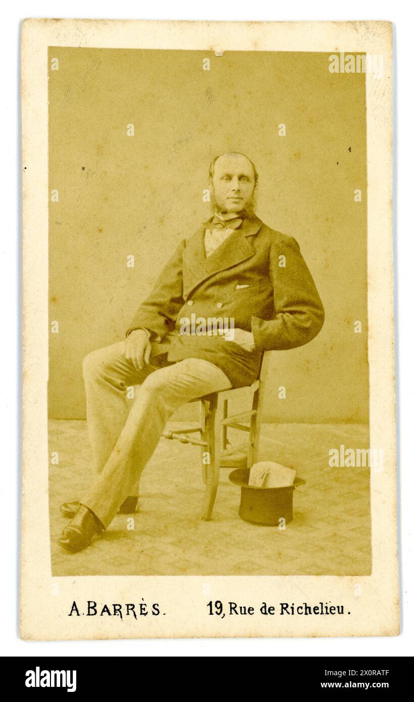 Original and clear 1860's French albumen print - Carte de Visite (visiting card or CDV) of French genltleman, seated on a chair with a top hat next to him.  From the photographic studio of A Barres, Rue de Richelieu, Paris, France. Circa late 1860's / early 1870's Stock Photo
