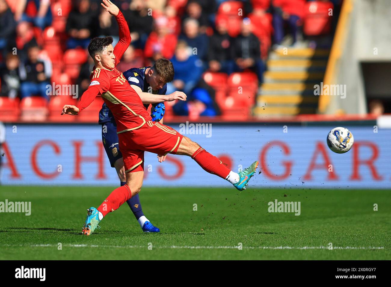 Pittodrie Stadium, Aberdeen, UK. 13th Apr, 2024. Scottish Premiership Football, Aberdeen versus Dundee; Aaron Donnelly of Dundee challenges for the ball with Jamie McGrath of Aberdeen Credit: Action Plus Sports/Alamy Live News Stock Photo