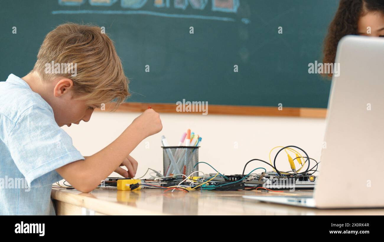 Diverse smart student working together to fix main board at stem class ...