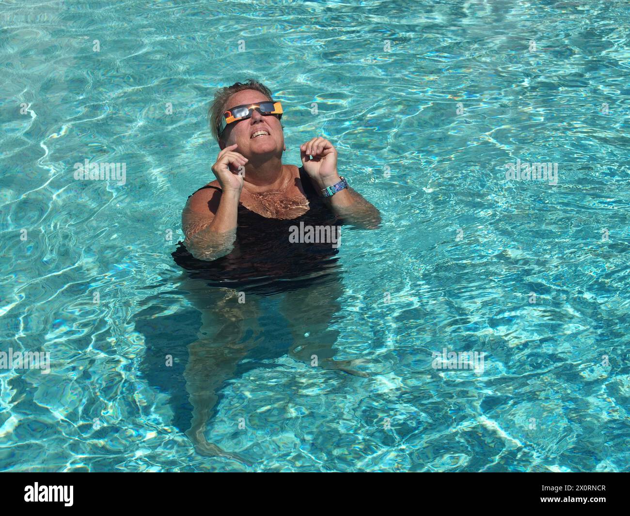 Senior women in a pool safely viewing a solar eclipse, April 8, 2024