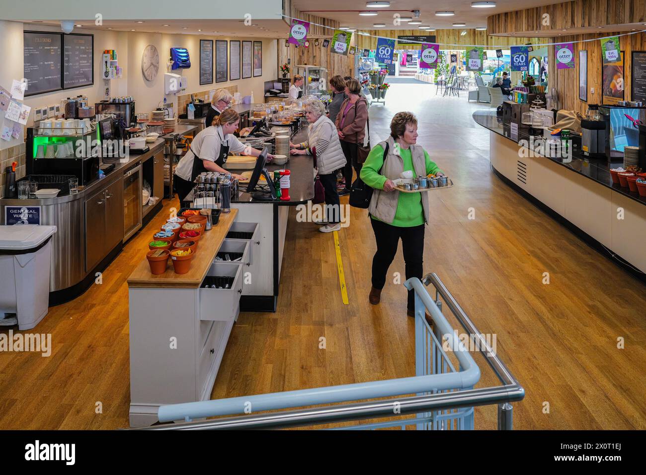 Cafeteria queue with female workers serving various meals and drinks at