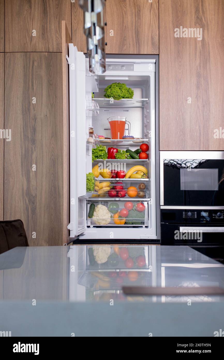 Open luxury refrigerator filled with lots of different types of food ...