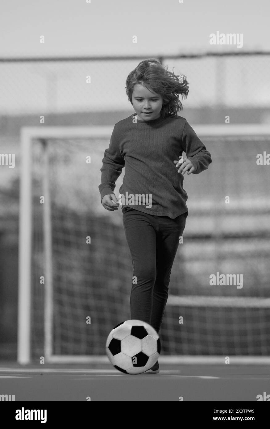 Child boy football or soccer player in action on stadium kicking ...