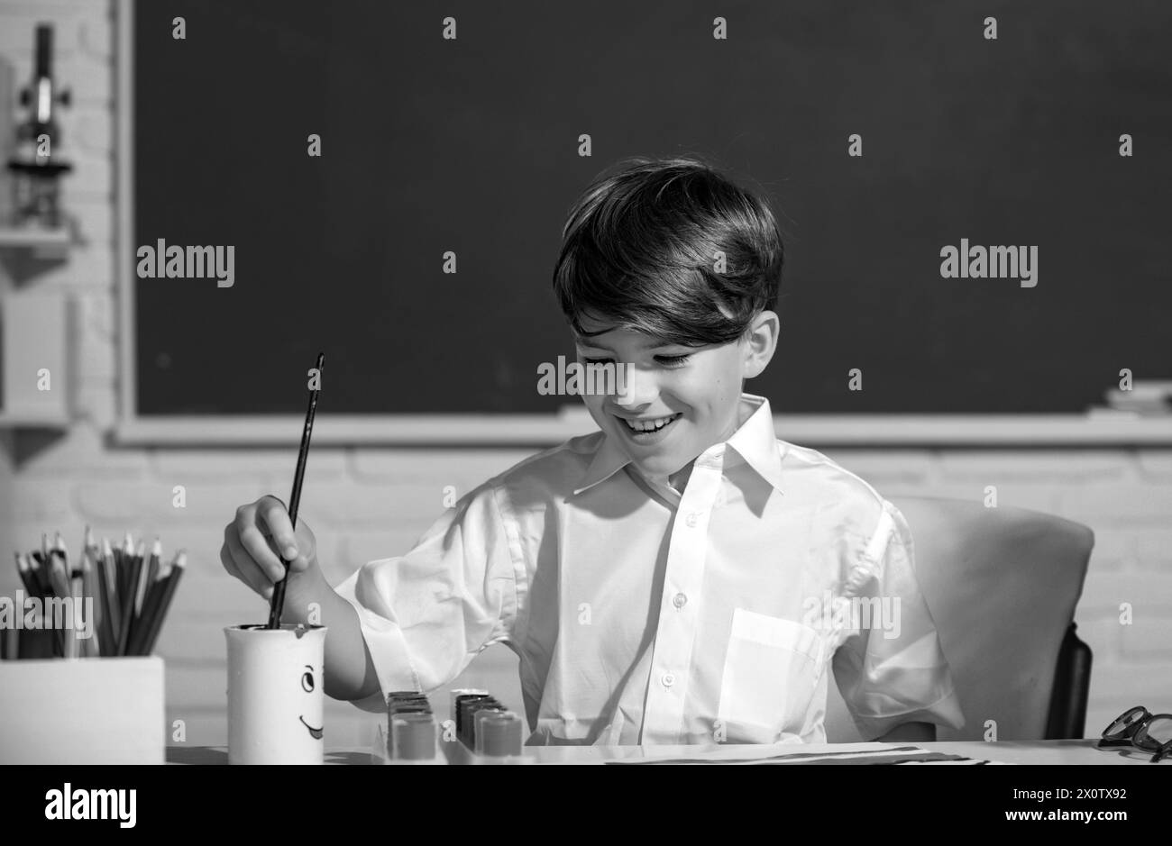 Child boy drawing cute draw using colored pencils at school or