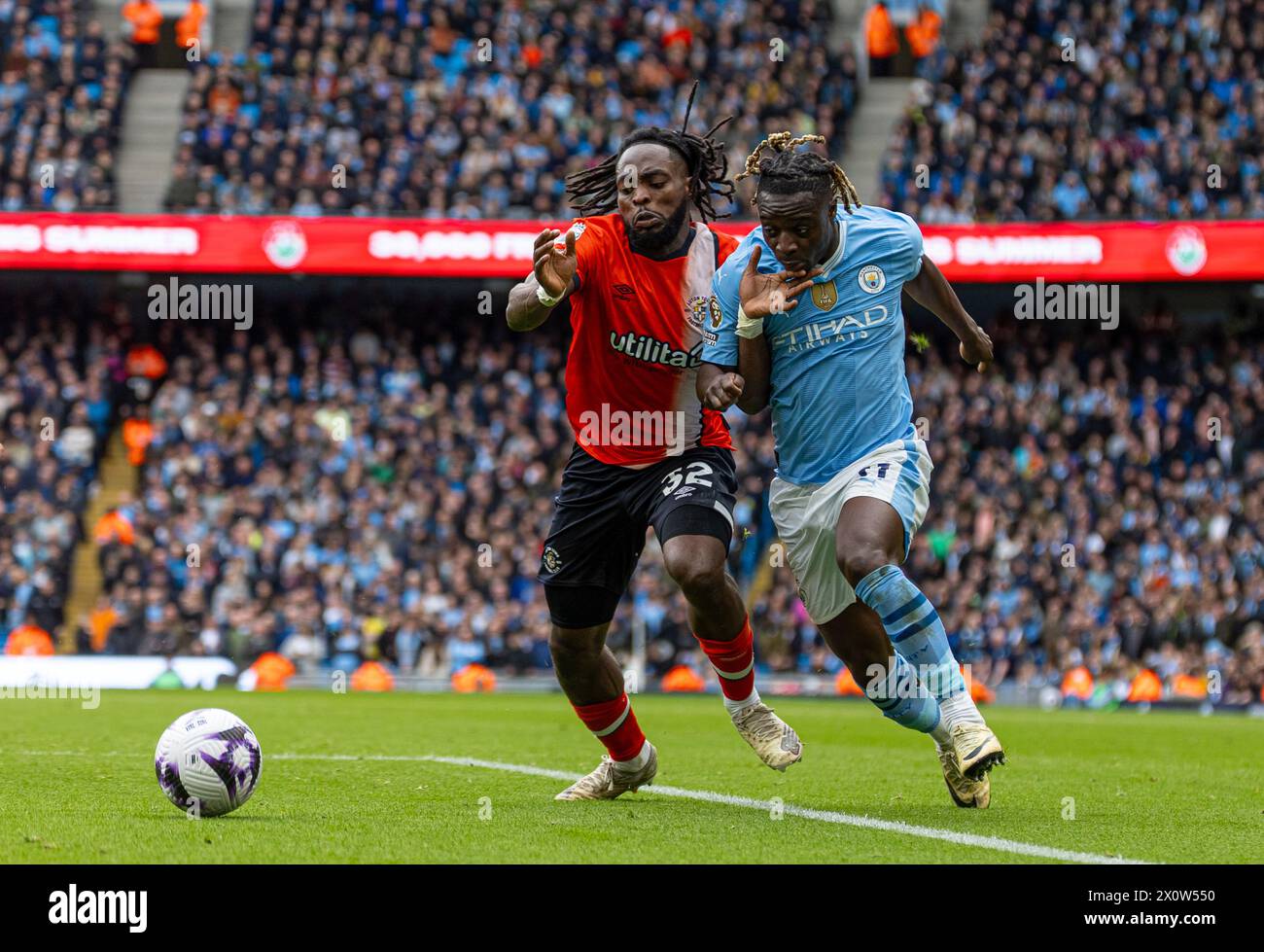 (240414) -- MANCHESTER, April 14, 2024 (Xinhua) -- Luton Town's Fred Onyedinma (L) vies with Manchester City's Jeremy Doku during the English Premier League match between Manchester City and Luton Town in Manchester, Britain, April 13, 2024. (Xinhua) FOR EDITORIAL USE ONLY. NOT FOR SALE FOR MARKETING OR ADVERTISING CAMPAIGNS. NO USE WITH UNAUTHORIZED AUDIO, VIDEO, DATA, FIXTURE LISTS, CLUB/LEAGUE LOGOS OR 'LIVE' SERVICES. ONLINE IN-MATCH USE LIMITED TO 45 IMAGES, NO VIDEO EMULATION. NO USE IN BETTING, GAMES OR SINGLE CLUB/LEAGUE/PLAYER PUBLICATIONS. Stock Photo