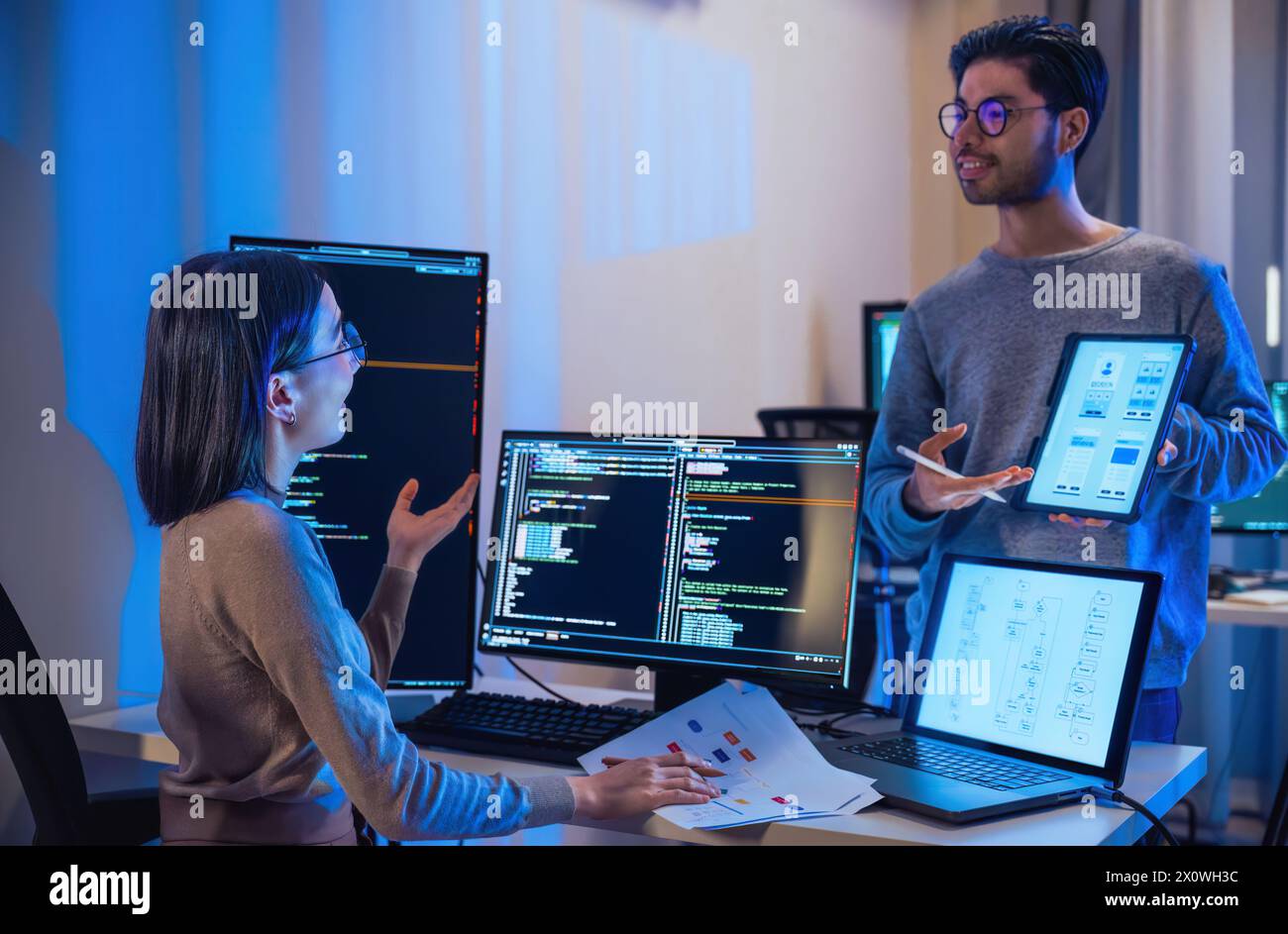 asian and Indian Developer  devops team discussion  about coding promgram with software computer at night in office Stock Photo