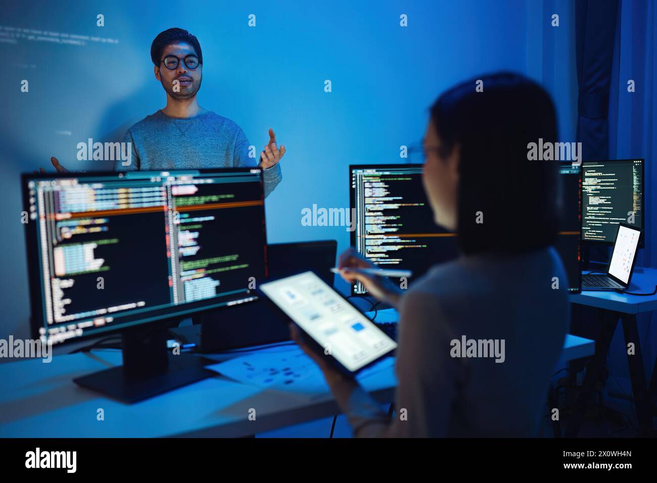 Indian man developer presentation about coding software data with devops team at night in office Stock Photo