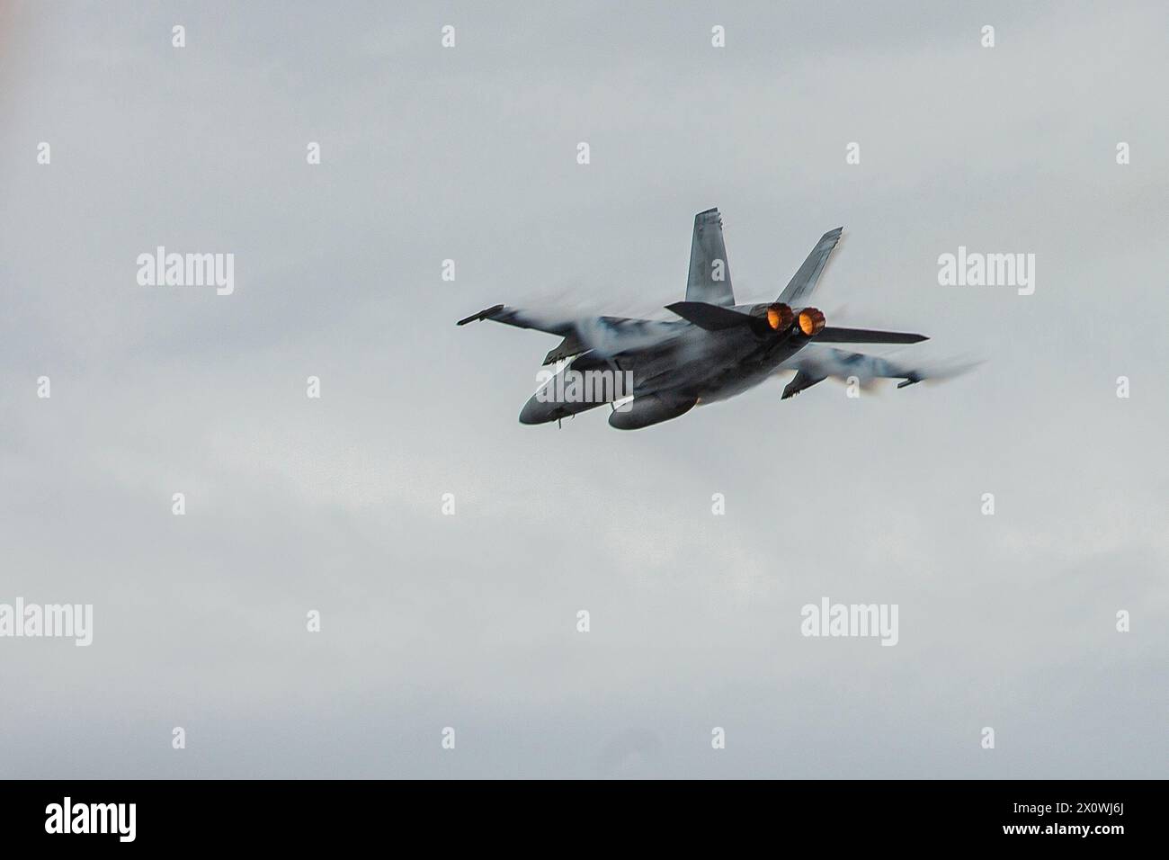 240413-N-MU675-1032 PACIFIC OCEAN (April 13, 2024) An F/A-18F Super Hornet, assigned to Strike Fighter Squadron (VFA) 122, flies over the Nimitz-class Stock Photo