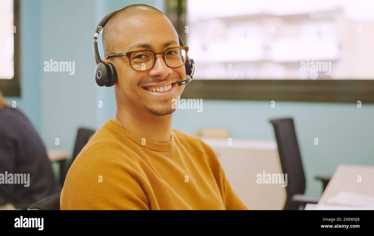 Smiling man using headset while working in a coworking Stock Photo