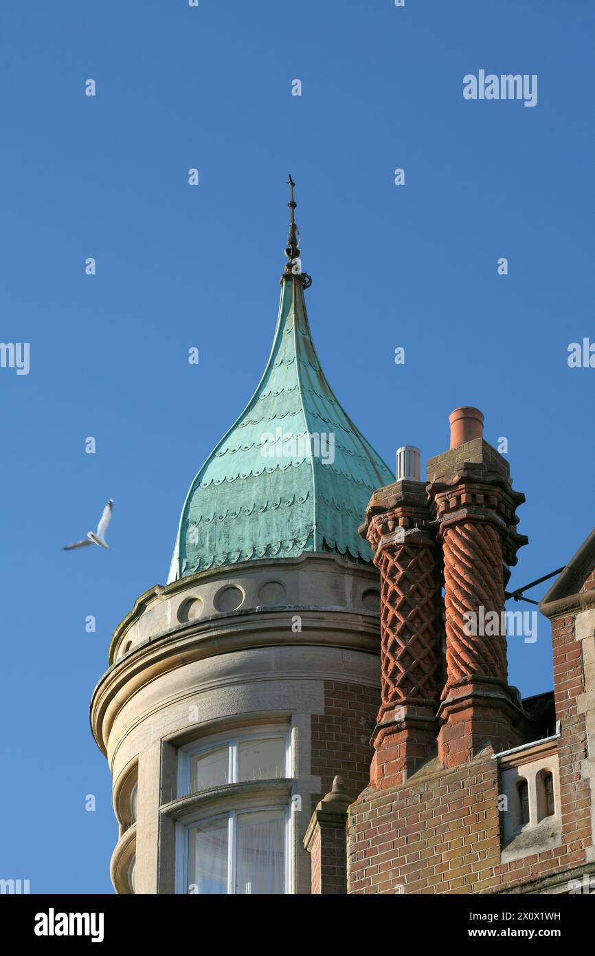 An attenuated ogee dome - almost a spire! - over third floor corner windows on a building in Hove. Plus Tudor-style chimneys. Stock Photo