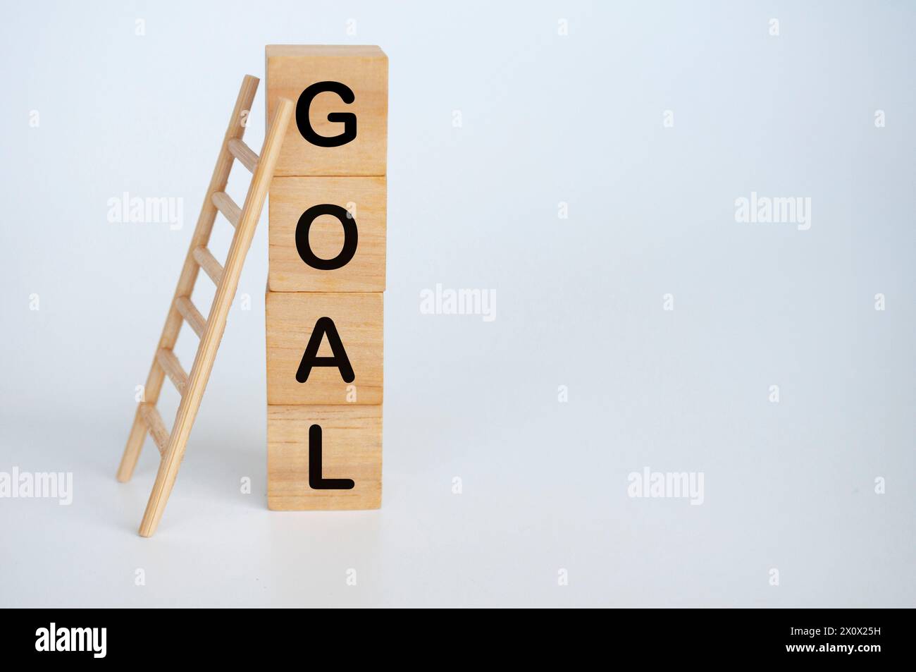 Goal text on wooden cubes with ladder on white background. Stock Photo
