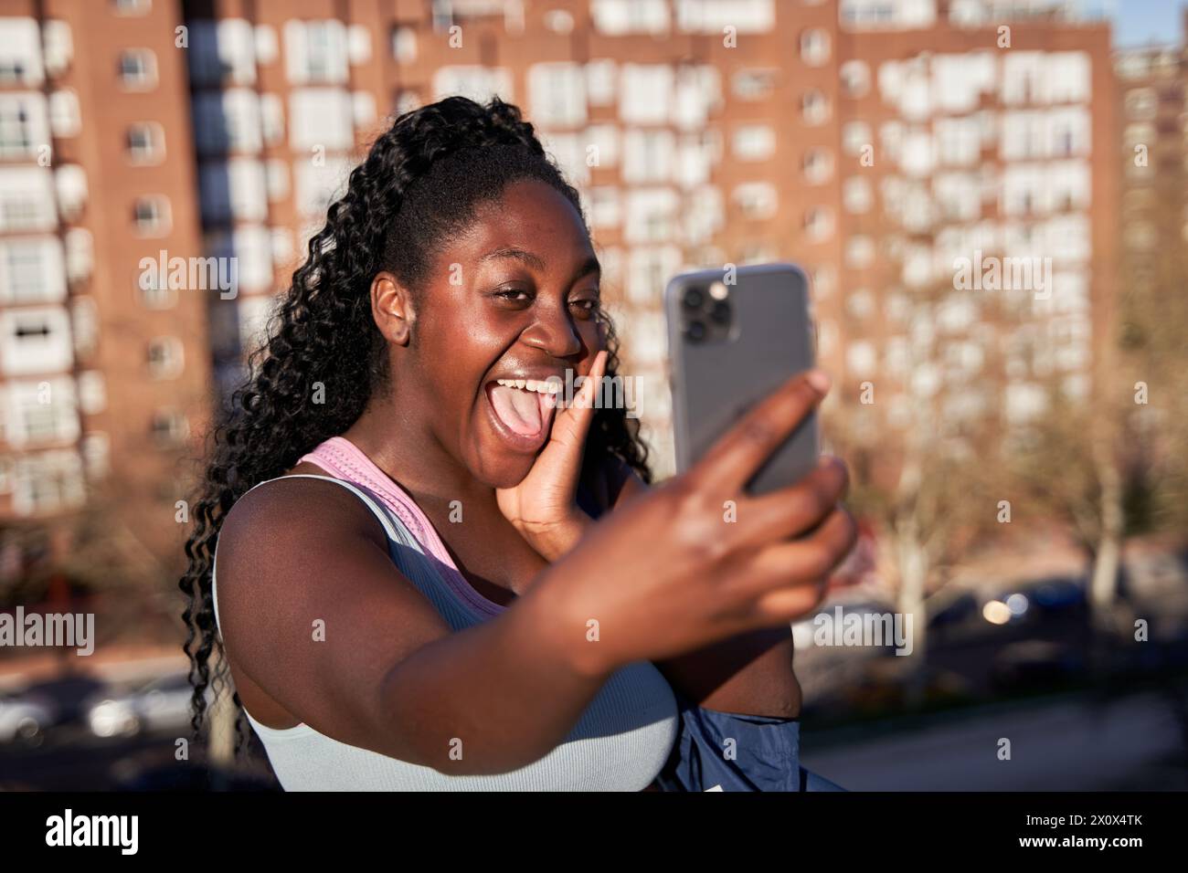 Cheerful African American woman making a video call with her smart phone. Generation z woman taking a selfie for social media. Stock Photo