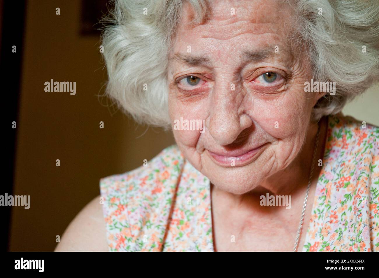 Portrait of old woman smiling and looking at the camera. Close view. Stock Photo