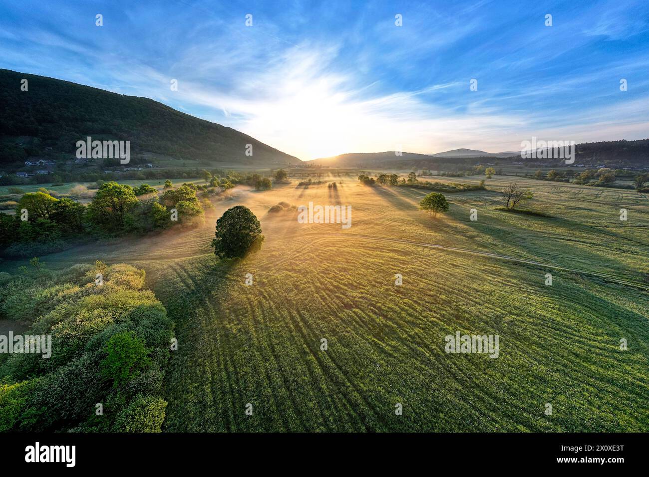 Spectacular morning light and mist on a beautiful meadow surrounded with lush forest close to Krka river, Dolenjska, Novo mesto, Slovenia Stock Photo