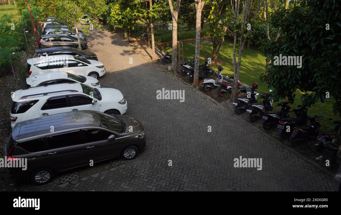 Cars and motorbikes parked neatly outside the room in a cafe and photographed from a high angle Stock Photo