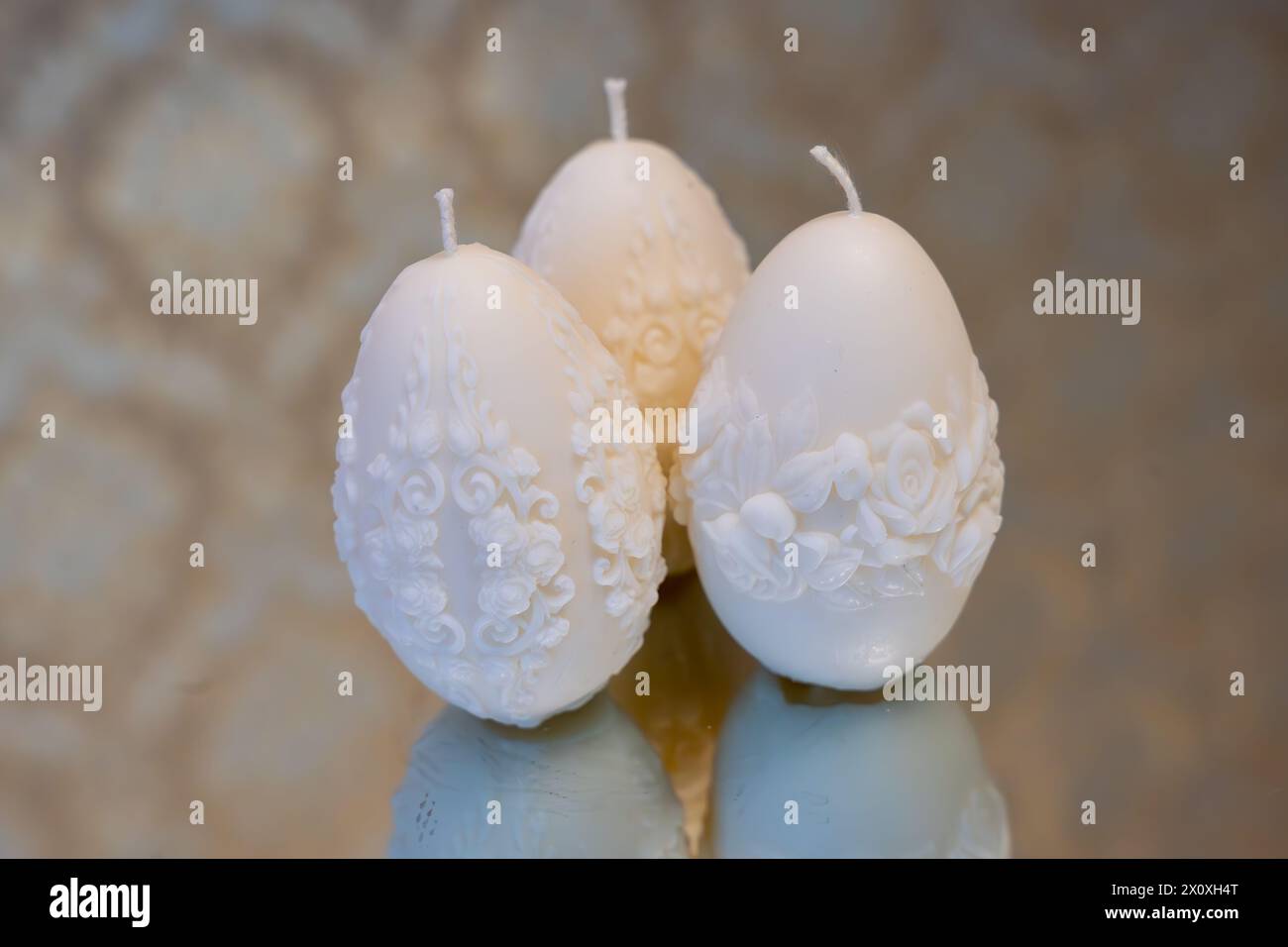 White easter egg soy wax candles. Mirror background Stock Photo