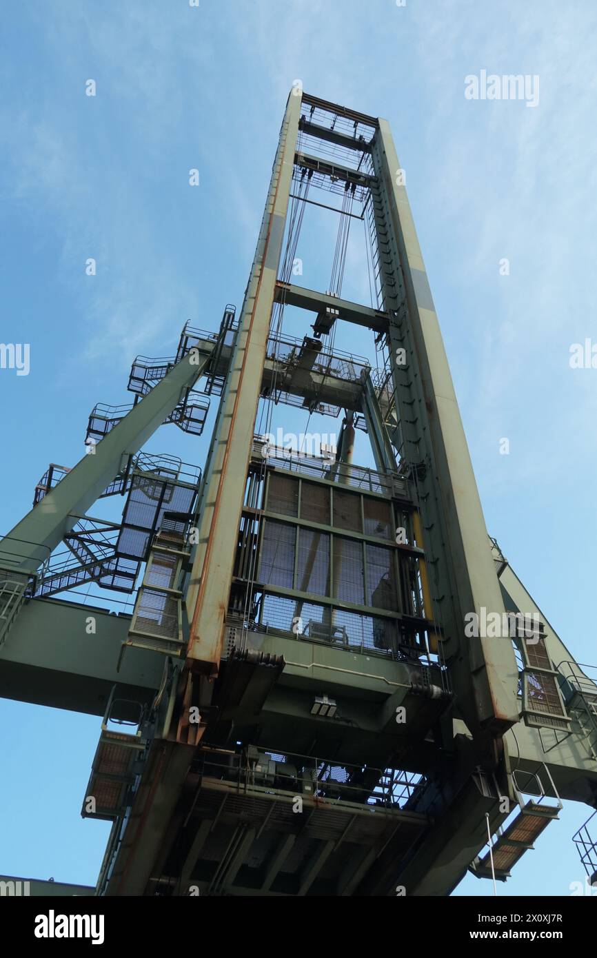 Green gantry crane in vertical position viewed from down in container terminal is waiting for cargo operation in Houston port in USA. Stock Photo