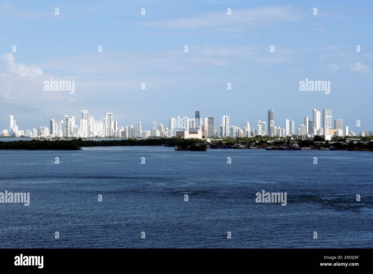 A distant silhouette of Cartegena, Colombia, with its tall modern buildings seen from the seaport on a sunny day. Stock Photo