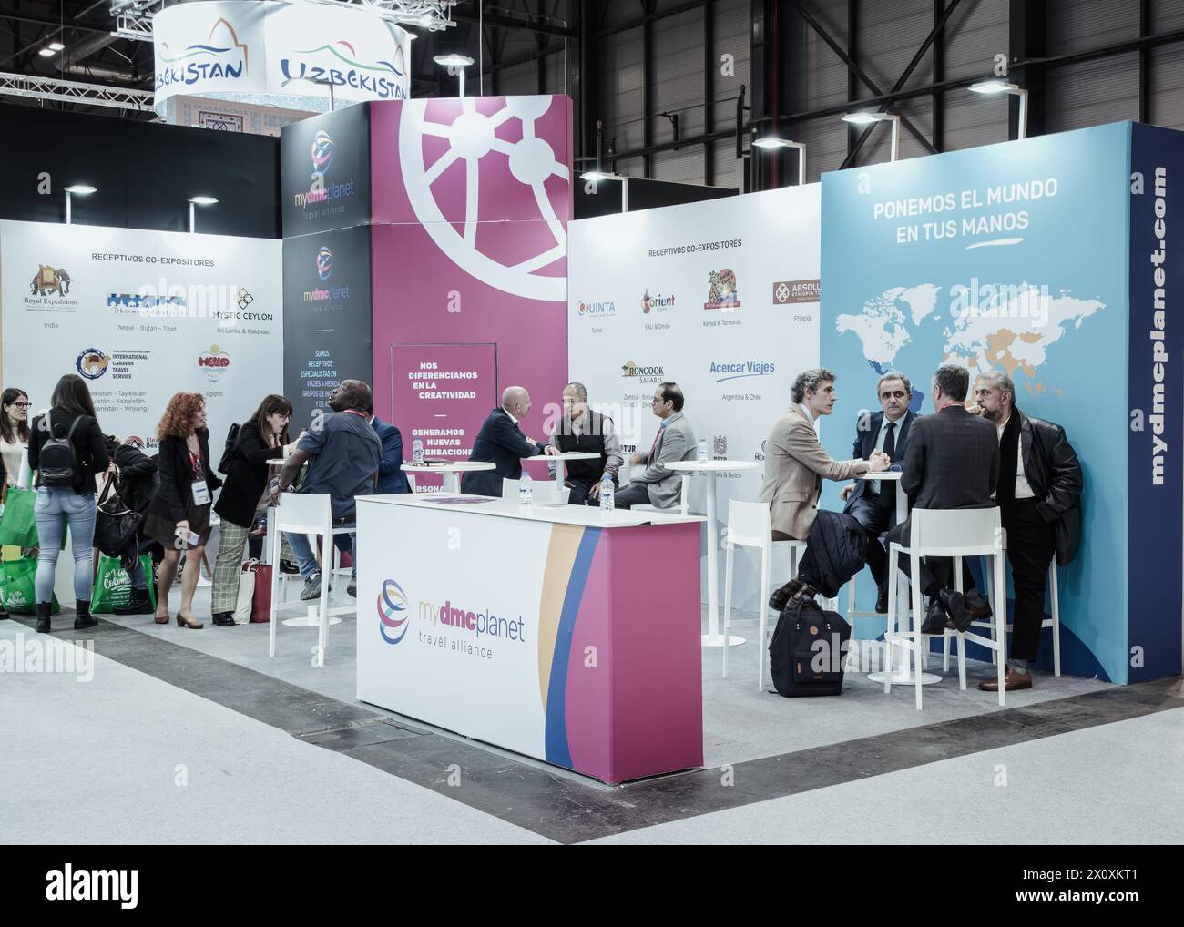 Madrid, Spain, January 25th 2024: Vibrant networking at Fitur: Tourism professionals engage amidst colorful displays Stock Photo