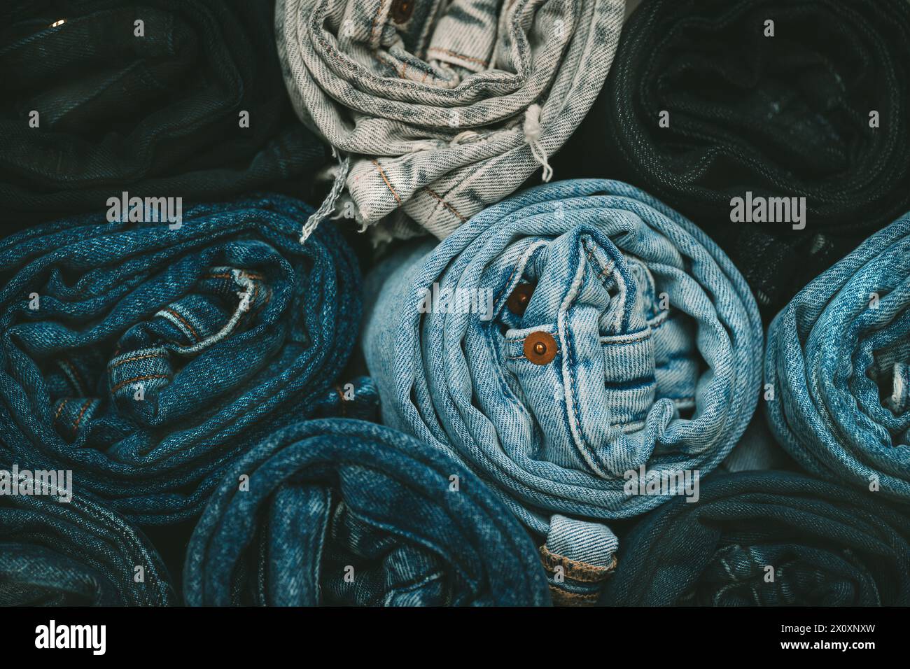 Background from stack of different color rolled jeans. Roll blue denim ...