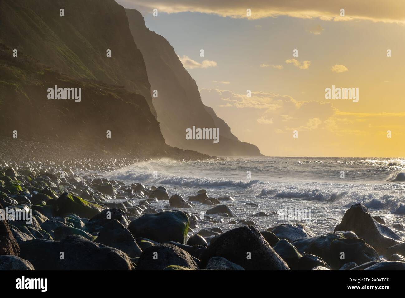 Volcanic rock cliffs Achadas da Cruz in backlit sunlight. Waves of the ...
