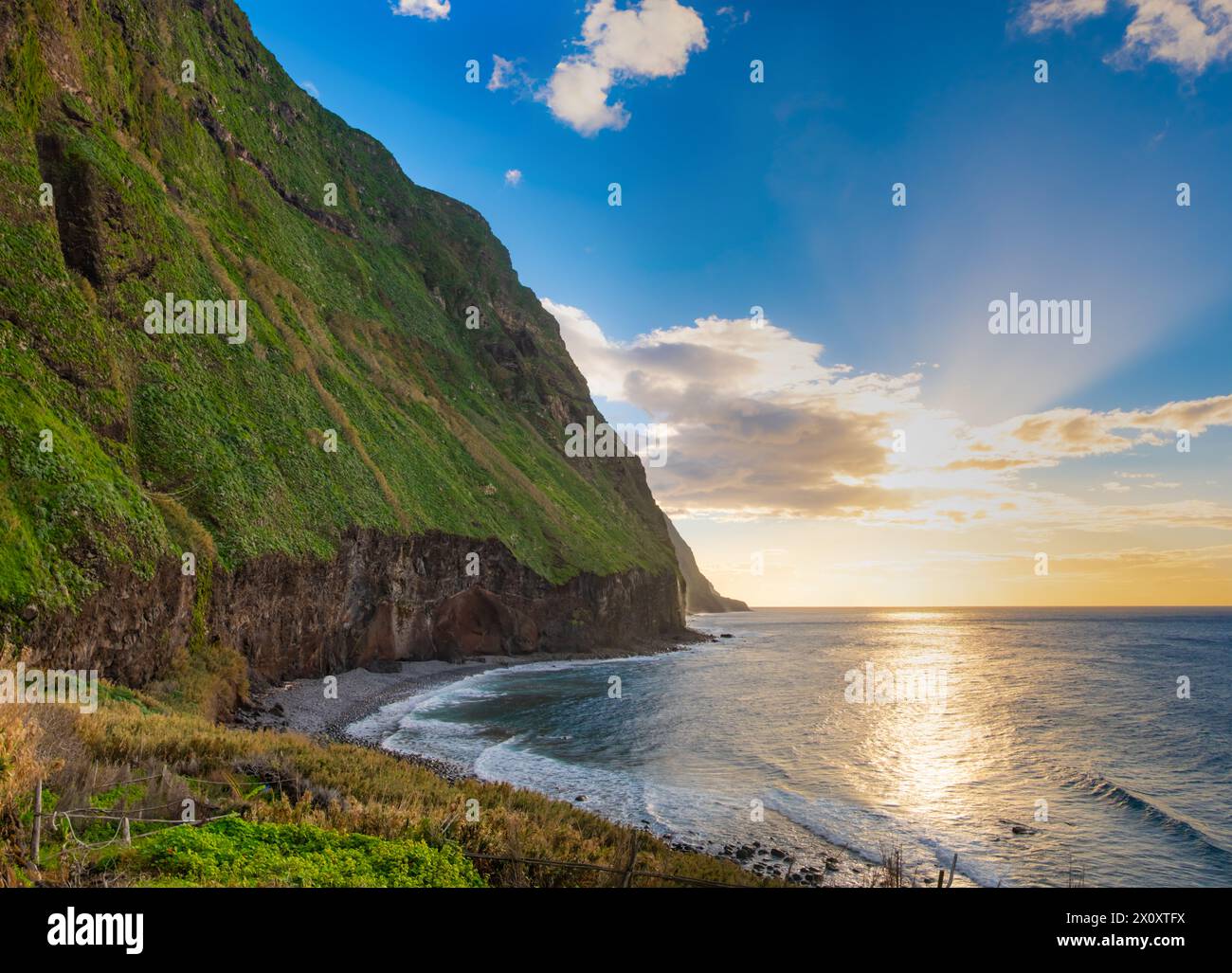 Volcanic rock cliffs Achadas da Cruz in backlit sunlight. Waves of the ...