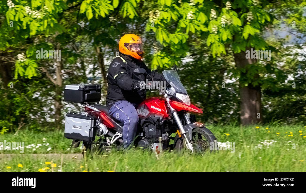 Milton Keynes,UK- Apr 14th 2024: 2021 red Sinnis Terrain 125 cc motorcycle travelling on a British road Stock Photo