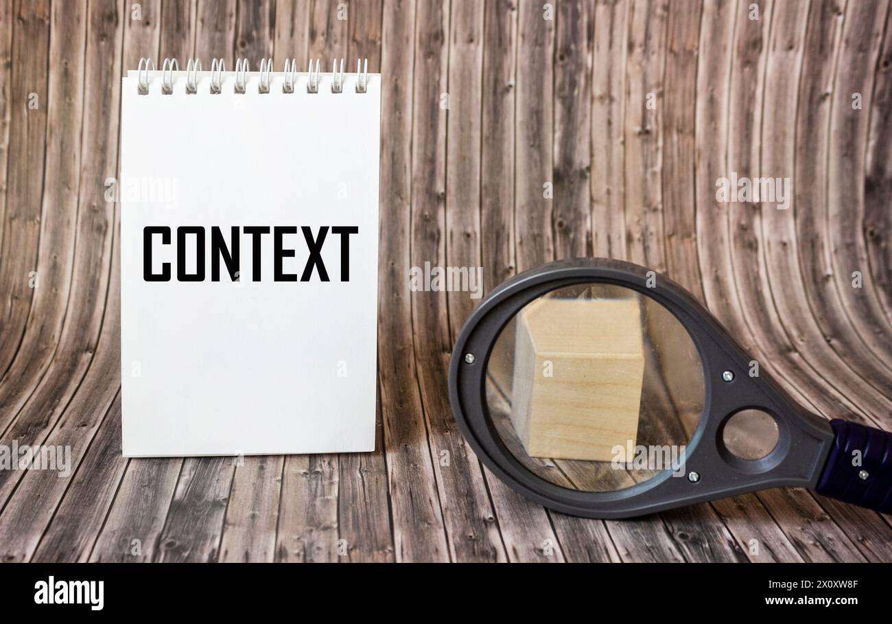 On the notepad near the magnifying glass are the words CONTEXT. Business concept image Stock Photo