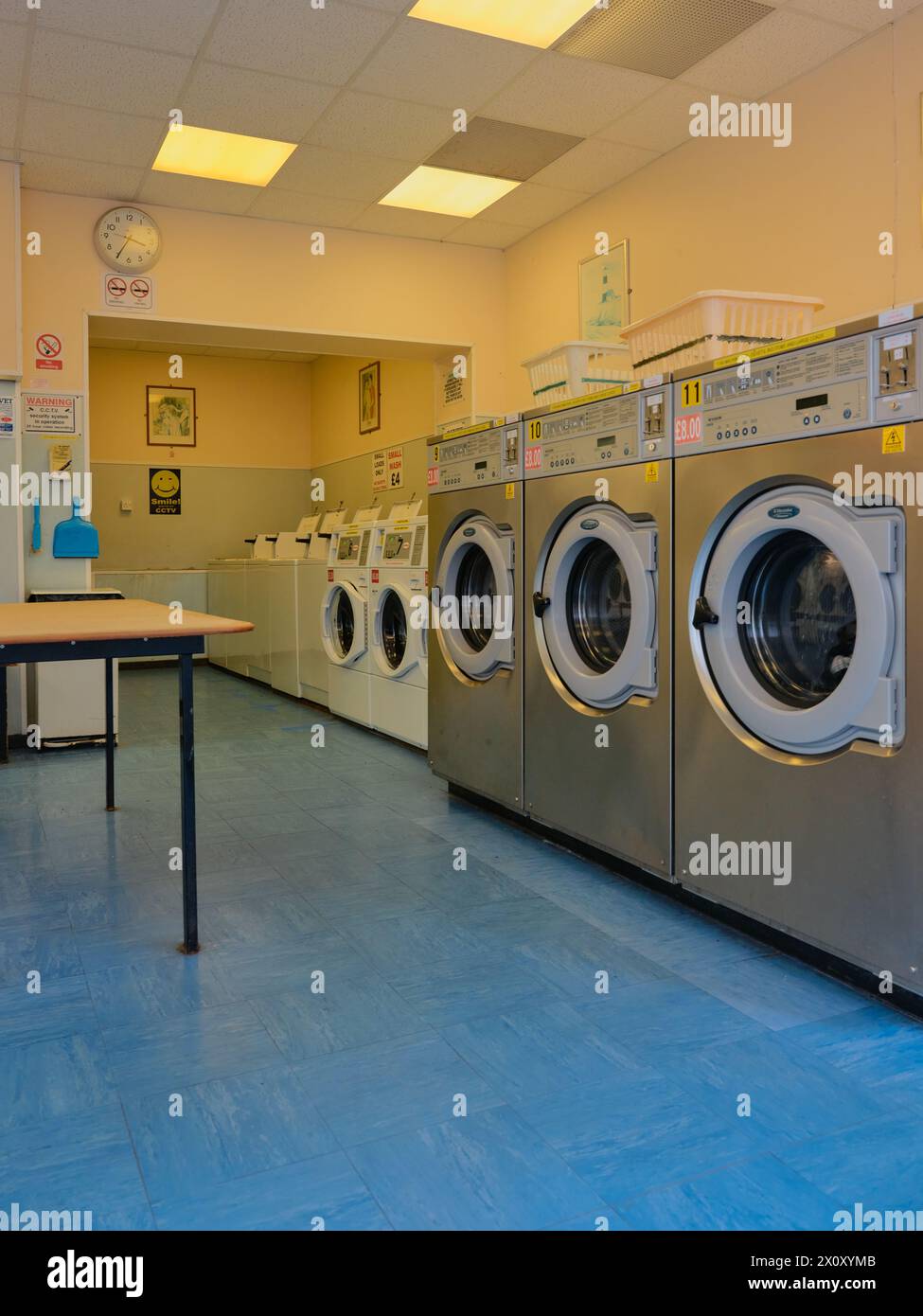 A typical laundromat / launderette interior with coin operated washing and drying machines