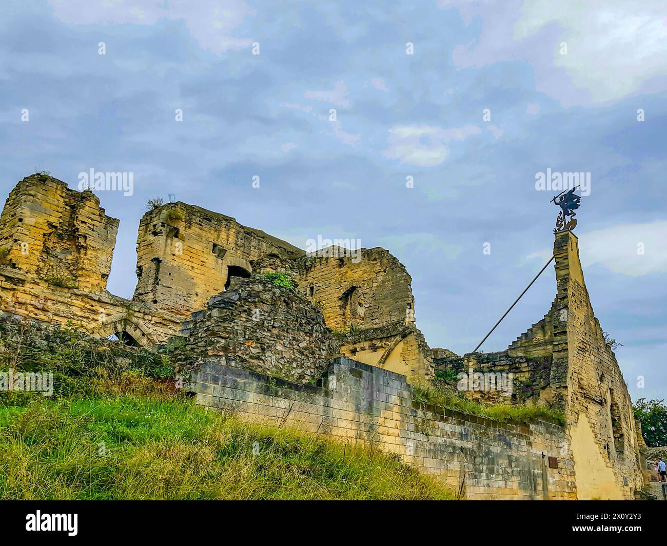 Ruined Valkenburg Castle on hill against cloud-covered blue sky, brick ...