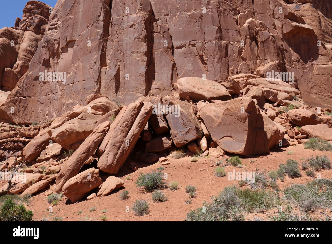 A pile of large boulders made of Entrada Sandstone in front of a wall of rock in Arches National park, Moab, Utah, USA Stock Photo