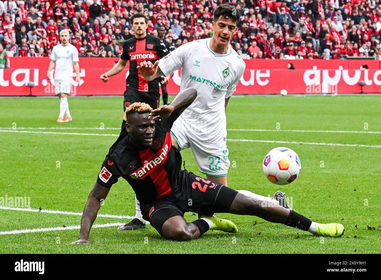 LEVERKUSEN - (l-r) Victor Boniface of Bayer 04 Leverkusen, Julian Malatini of SV Werder Bremen during the Bundesliga match between Bayer 04 Leverkusen and Werder Bremen at the Bay Arena on April 14, 2024 in Leverkusen, Germany. ANP | Hollandse Hoogte | GERRIT VAN COLOGNE Stock Photo