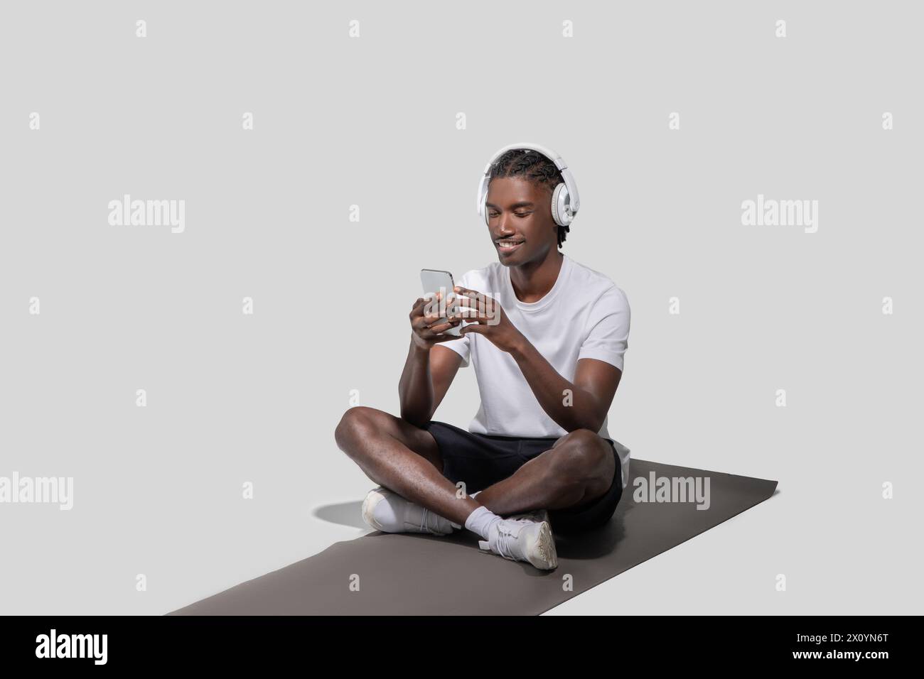 Young man smiling using smartphone and headphones Stock Photo