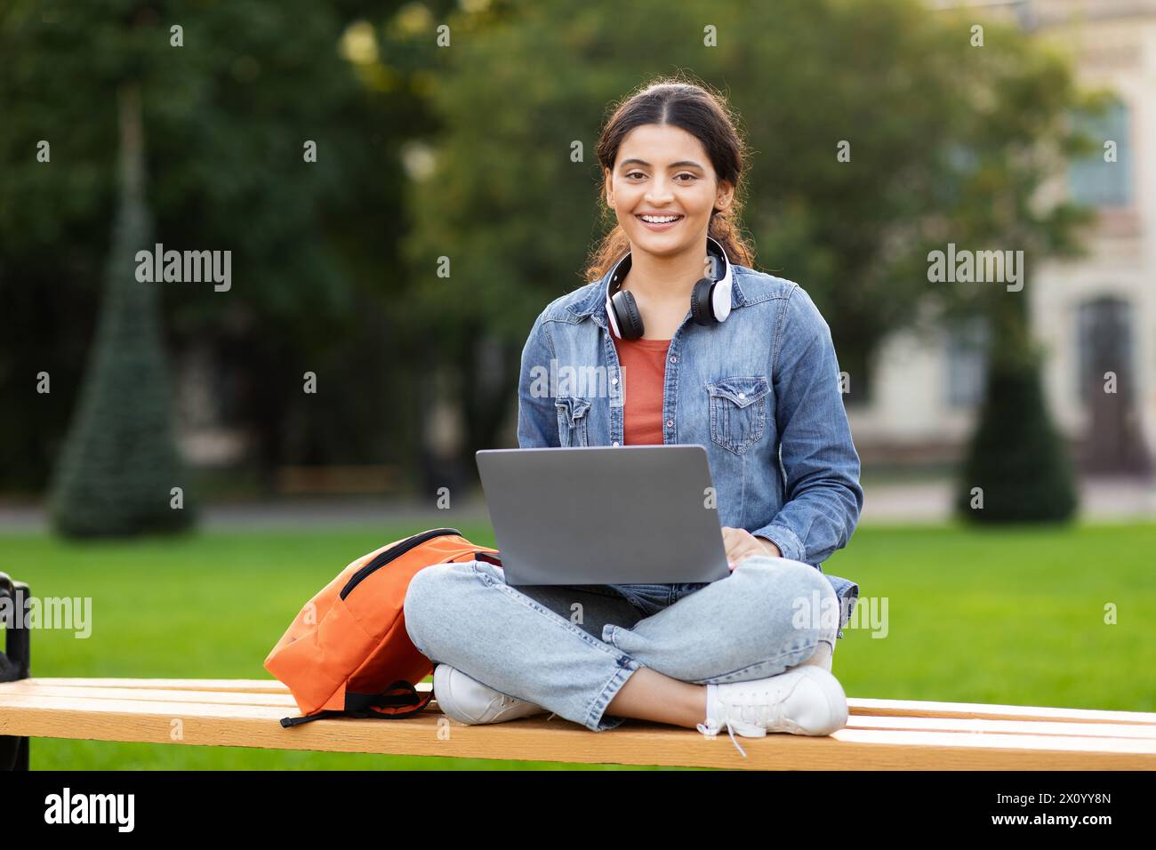 Relaxed woman student studying outdoors with laptop Stock Photo