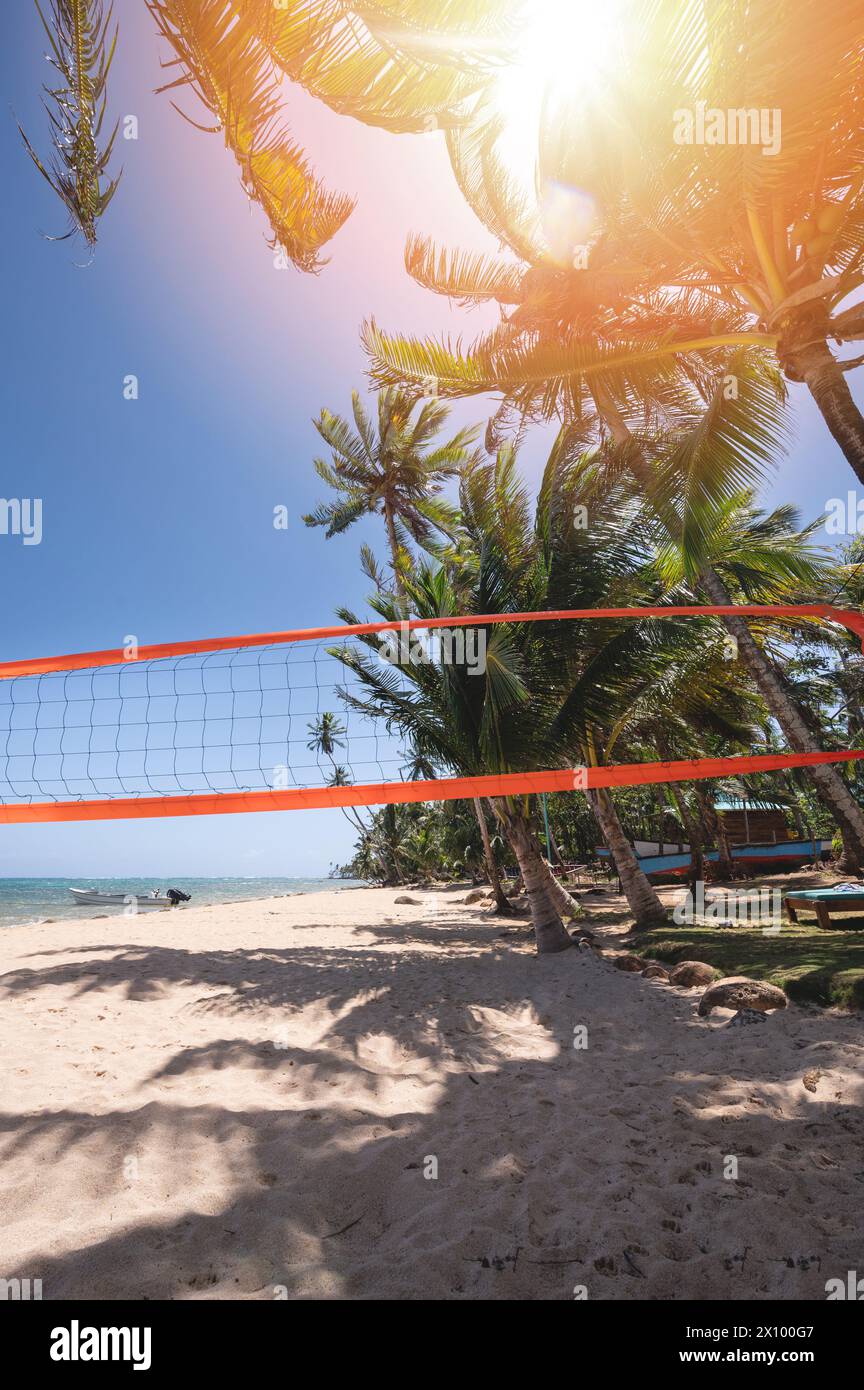 Beach volleyball field in palm tree shade on bright sunny day Stock Photo