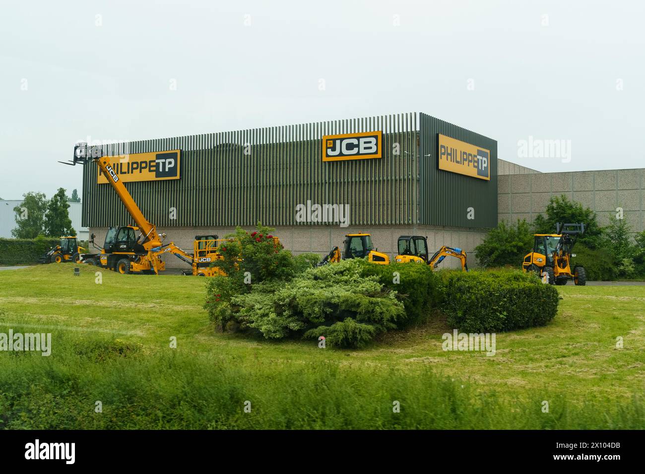 Noyelles-Godeau, France - May 22, 2023:A fleet of JCB construction machinery is lined up outside the Philippe TP warehouse, under a cloudy sky, indica Stock Photo