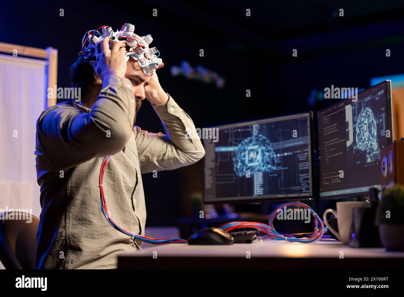Computer scientist puts EEG headset on, starting mind upload process, trying to gain bionic powers. Man using high tech neuroscientific gear to transfer consciousness into cyberspace Stock Photo