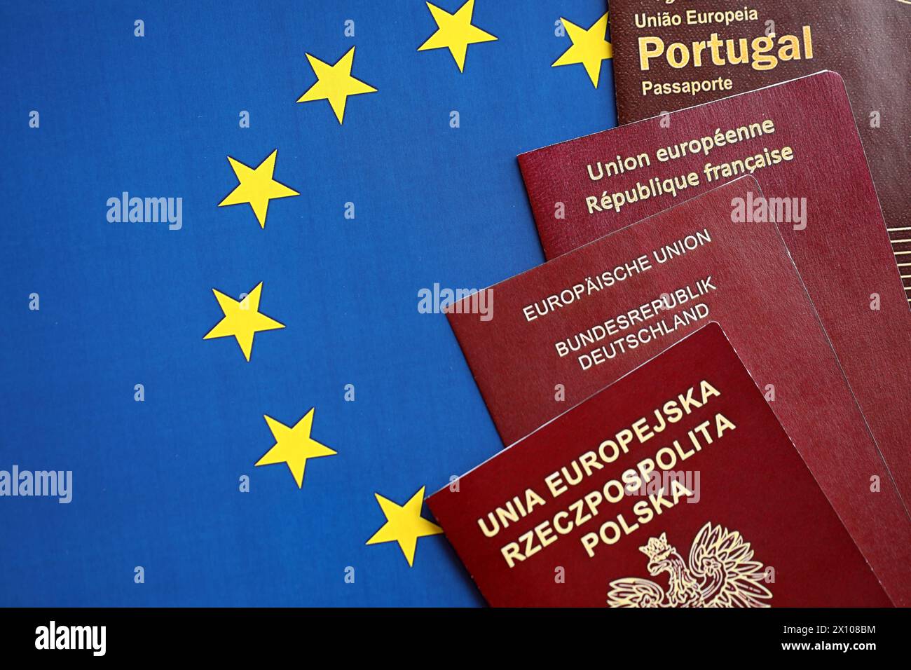 European union countries passports on blue EU flag close up. Portugal, German, French and Polish passports Stock Photo