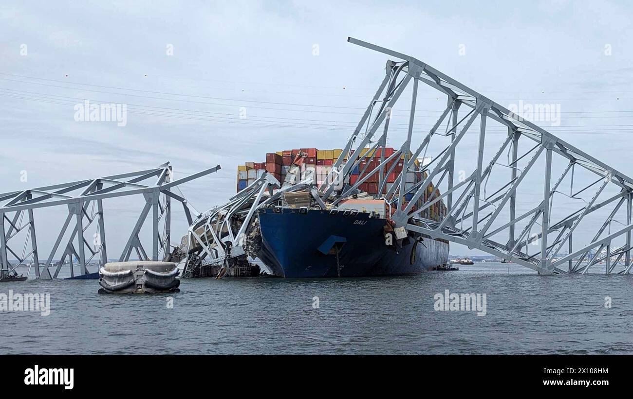 Dundalk, United States of America. 26 March, 2024. The entangled cargo carrier MV Dali encased in the steel trusses of the collapsed Francis Scott Key Bridge on the Fort McHenry channel at first light, March 26, 2024, near Dundalk, Maryland. The bridge was struck by the 984-foot container ship in the early morning on March 26th and collapsed killing six workers and shutting the Port of Baltimore. Credit: Dave Adams/USACE/Alamy Live News Stock Photo