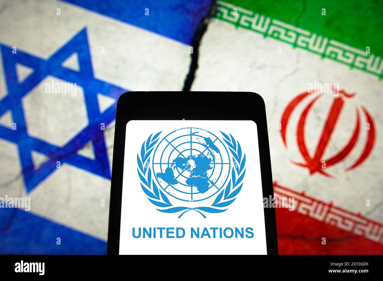 In this photo illustration, the United Nations (UN) logo is displayed on a smartphone screen and flags of Israel and Iran in the background. Stock Photo